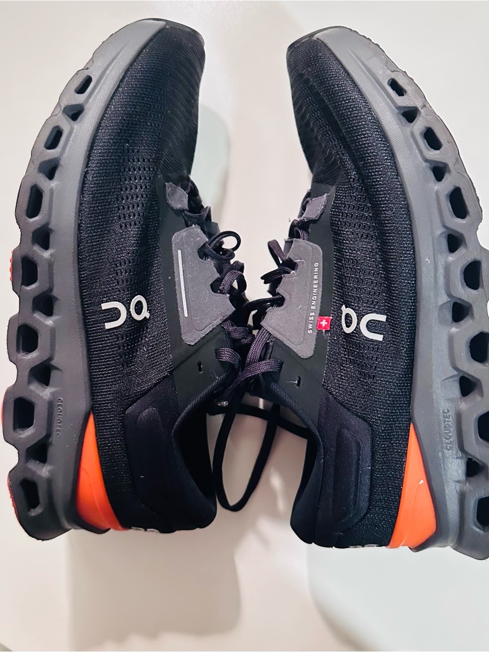 On Running Men’s Black Athletic Shoes with Orange Heel Accents